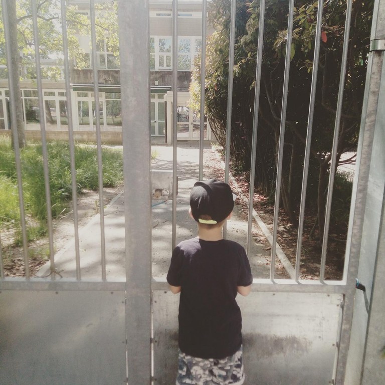 Bambino dietro al cancello chiuso