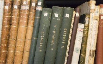 Volumi storici disposti su uno scaffale