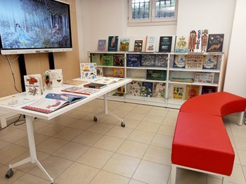 Laboratorio di Letteratura per l'infanzia: albi illlustrati, divanetti in zona lettura, monitor interattivo