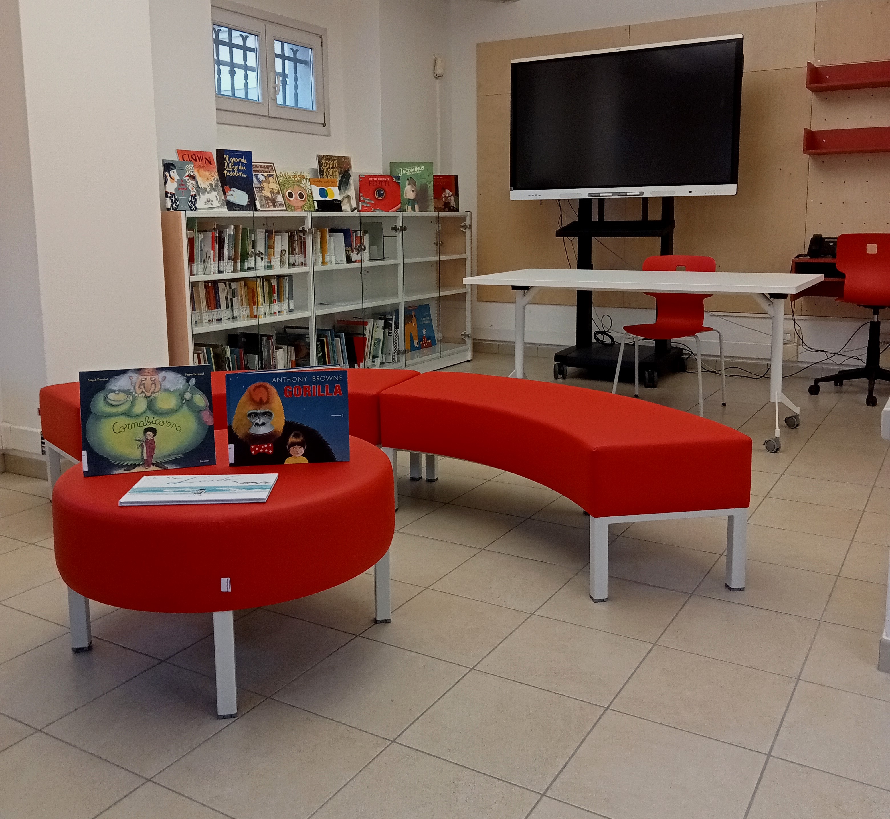 Albi illlustrati, tribuna e divanetti in zona lettura e drammatizzazione, monitor interattivo