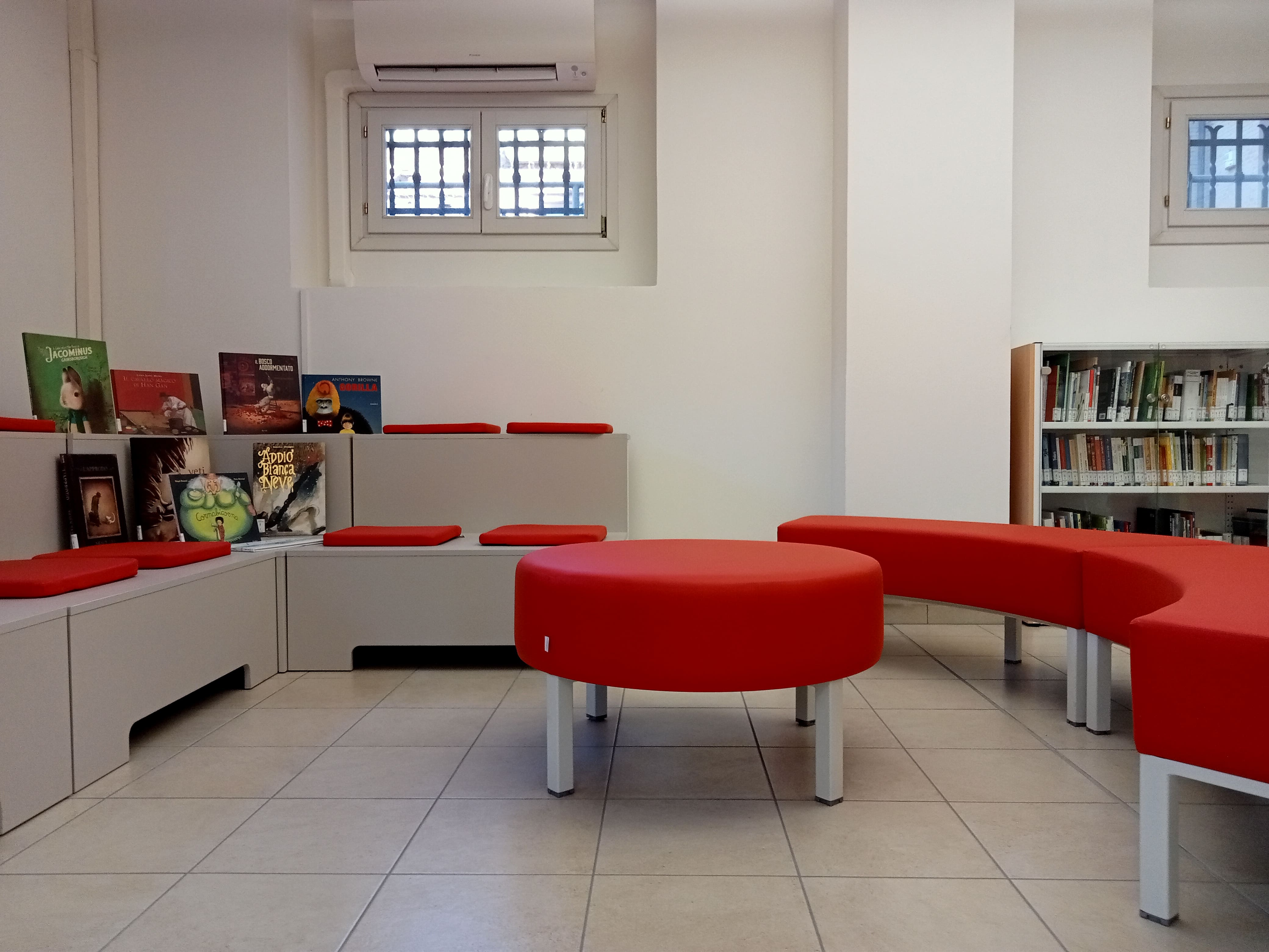 Albi illlustrati, tribuna e divanetti in zona lettura e drammatizzazione