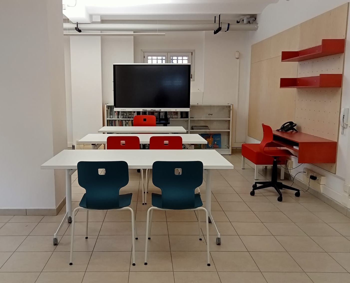 Tavoli e sedute in zona studio/didattica, monitor interattivo